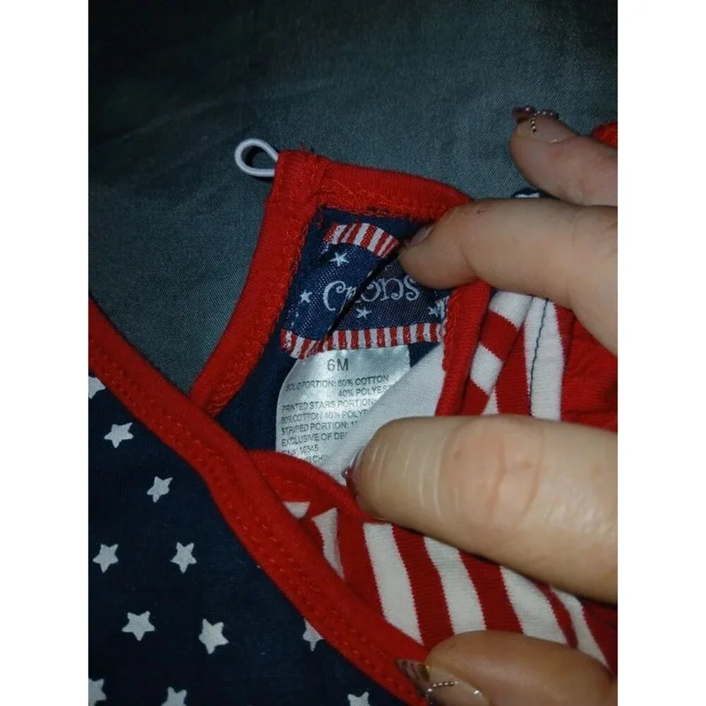 patriotic-themed outfit for a baby girl featuring a stars and stripes design. 6m